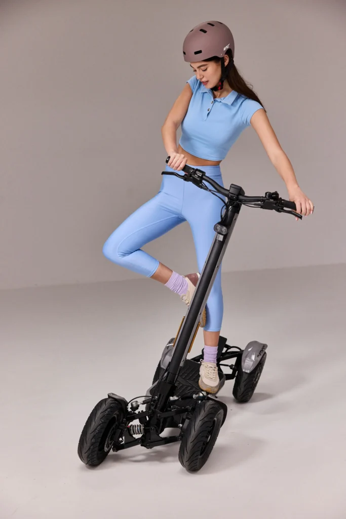 Woman riding MIA SPYQE 2x4 electric scooter with large wheels and dual motor power built for stable city commuting discover the SPYQE today