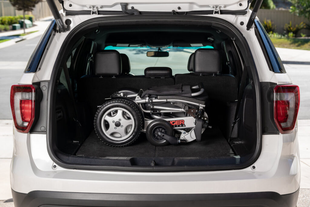Porto Mobility Ranger Quattro XL folding power wheelchair folded in the open rear cargo area of a white vehicle